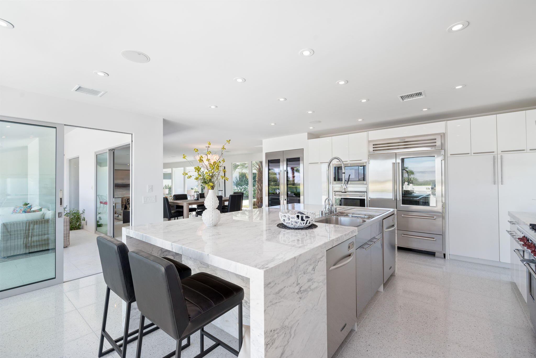 70288 Calico Road Rancho Mirage, CA 92270 - Photo 38 of 72 a dining hall with stainless steel appliances kitchen island granite countertop a dining table chairs and view living room
