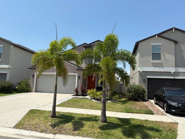 9616 Lemon Drop Loop Sun City Center, FL 33573 - Photo 4 of 53 a front view of a house with a yard