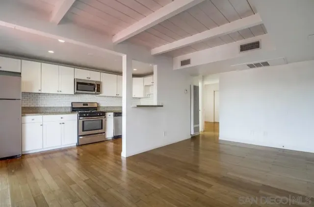 a kitchen with granite countertop a refrigerator and a stove top oven