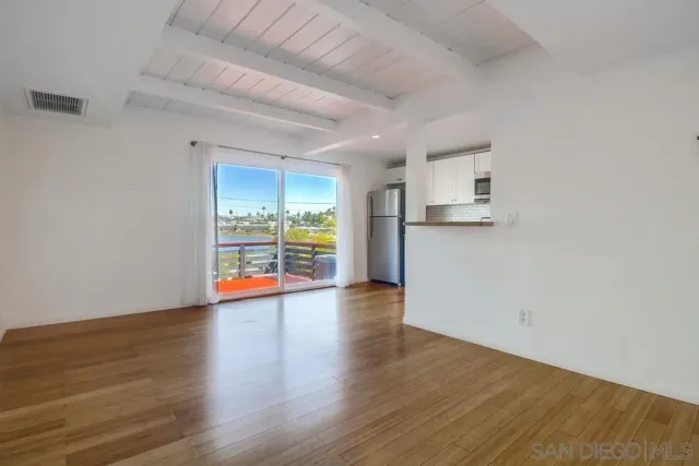 a view of empty room with wooden floor and fireplace