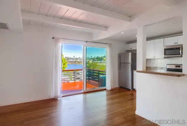 a kitchen with stainless steel appliances a refrigerator and a wooden floor