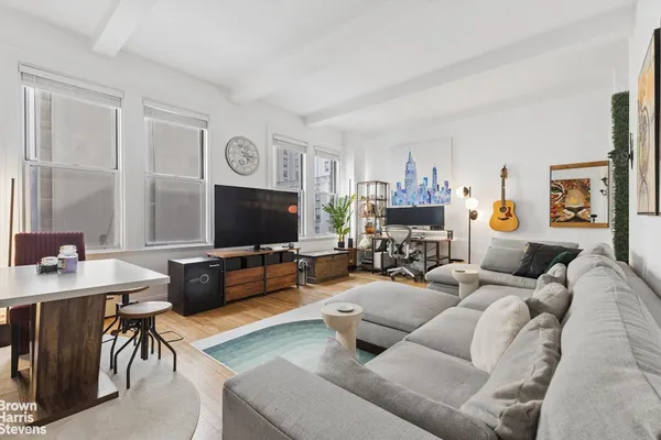a living room with furniture a flat screen tv and a table