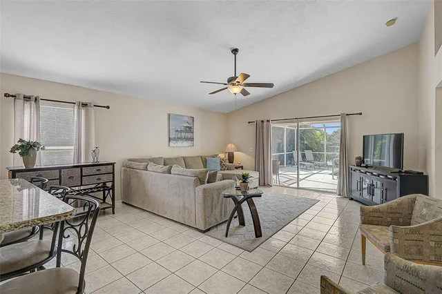 a living room with furniture a flat screen tv and a large window
