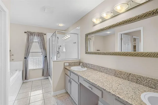 a bathroom with a granite countertop sink a mirror and a shower