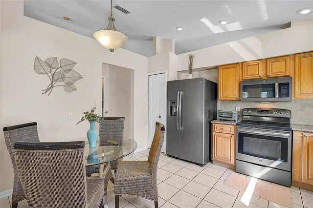 a kitchen with stainless steel appliances granite countertop a refrigerator a stove a microwave oven a sink with island and chairs