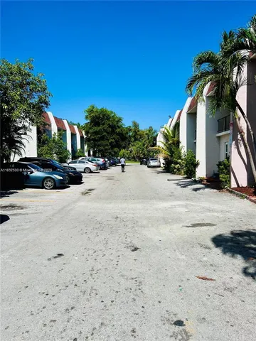 a view of road with card parked on side and road