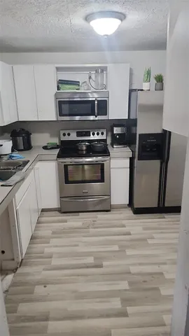 a kitchen with a stove and white cabinets
