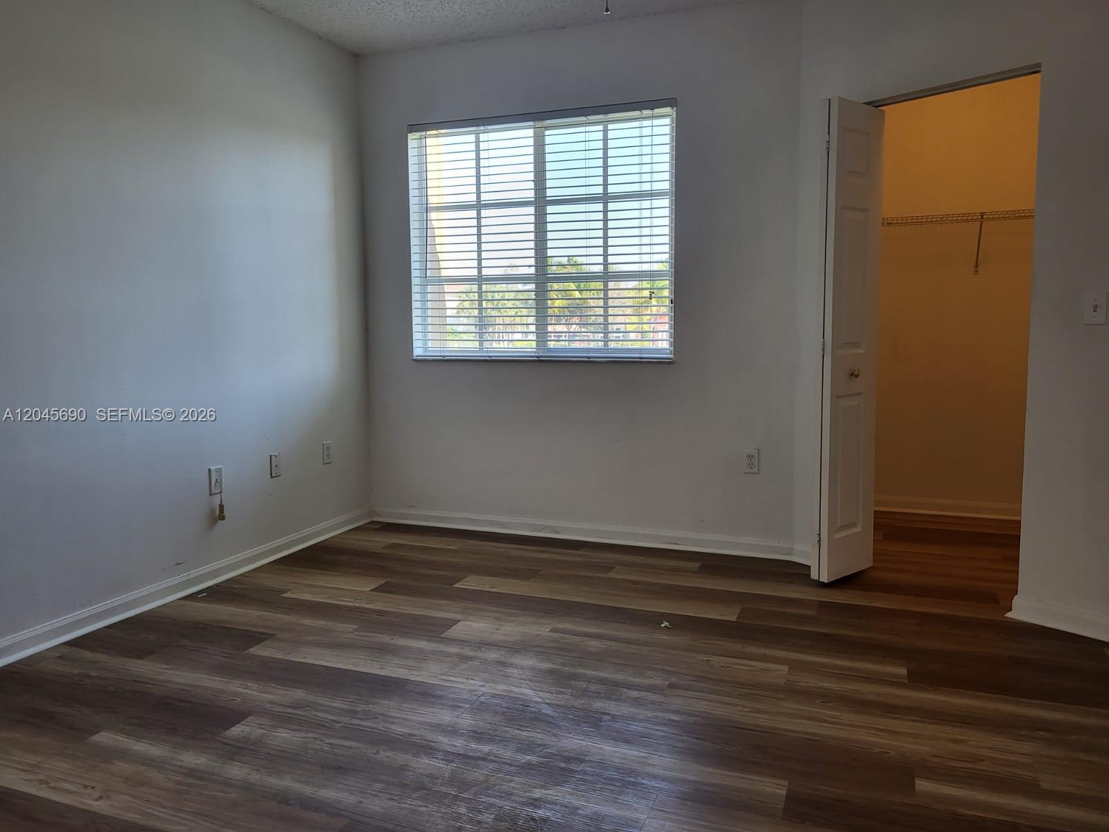 8070 North Nob Hill Road, Unit 208 Tamarac, FL 33321 - Photo 8 of 16 an empty room with wooden floor and windows