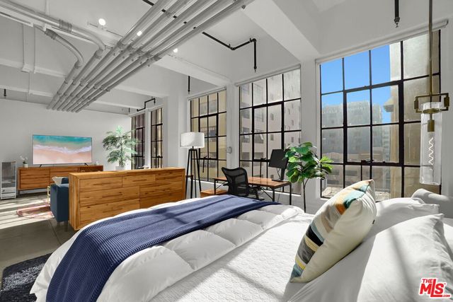 a bedroom with a bed a chandelier and potted plants on the table