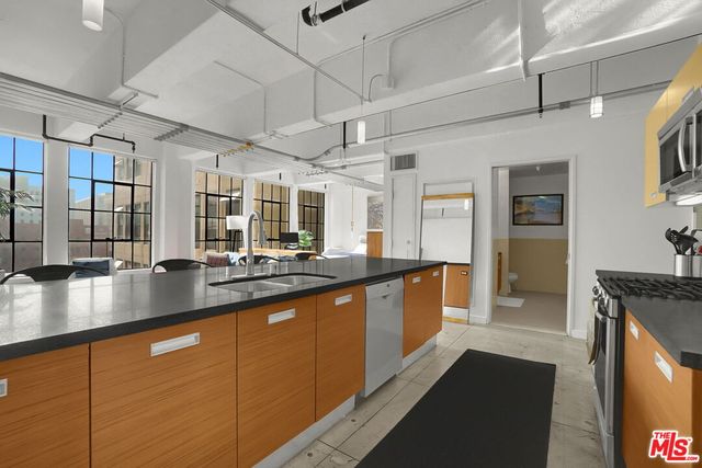 a large kitchen with stainless steel appliances granite countertop a lot of counter space and a sink