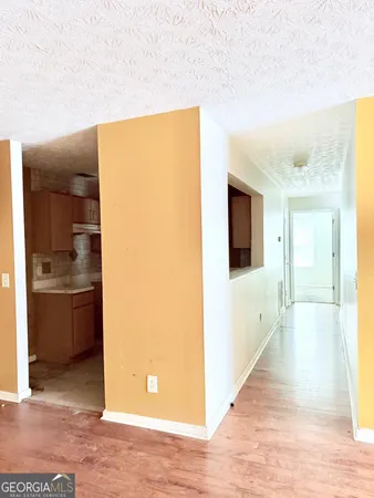 a view of a hallway with wooden floor and a living room