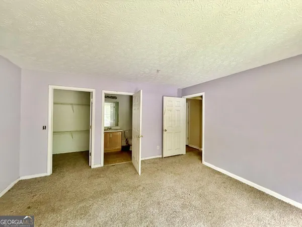 an empty room with closet and a window