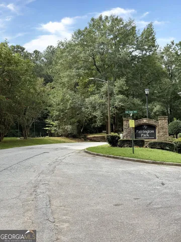 a view of a house with a big yard and large trees