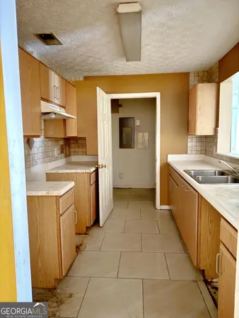 a kitchen with a sink stove and cabinets