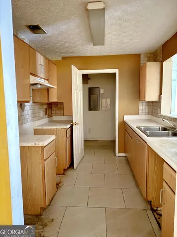 a kitchen with a sink stove and cabinets