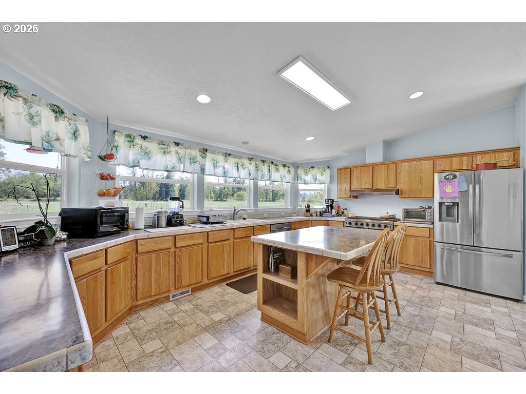 38277 Wheeler Road Dexter, OR 97431 - Photo 14 of 47 a kitchen with stainless steel appliances granite countertop a table and chairs in it