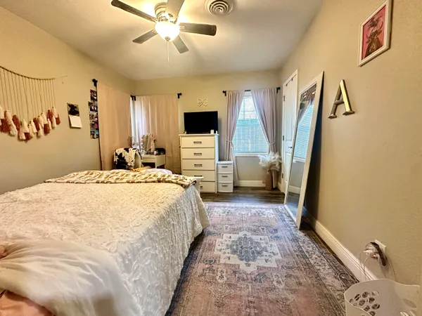 a spacious bedroom with a bed and a flat screen tv