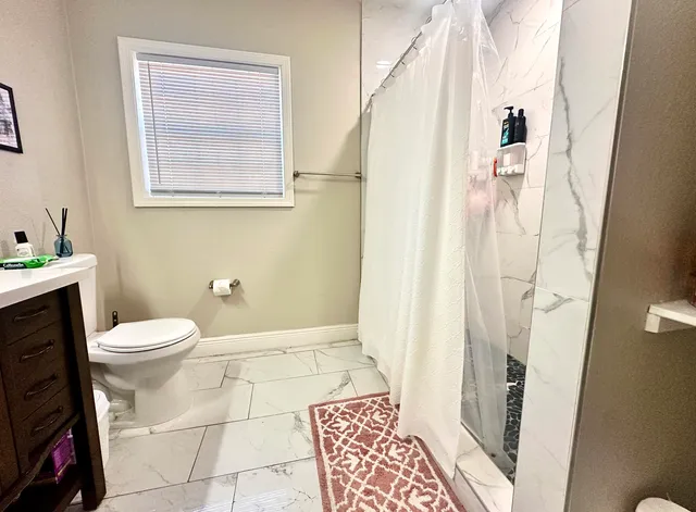 a bathroom with a toilet and a shower