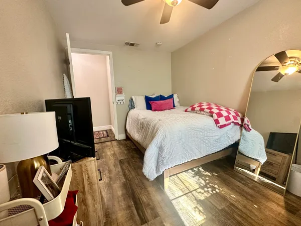 a bedroom with a bed and wooden floor