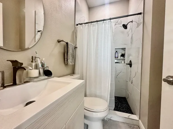 a bathroom with a sink toilet and shower