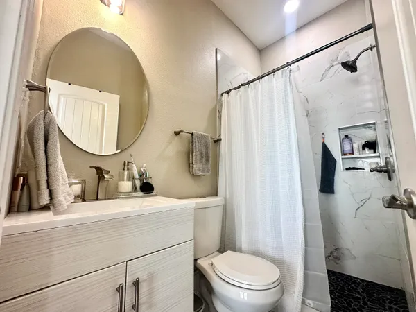 a bathroom with a sink mirror toilet and vanity