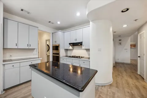 a kitchen with stainless steel appliances granite countertop a sink refrigerator and cabinets