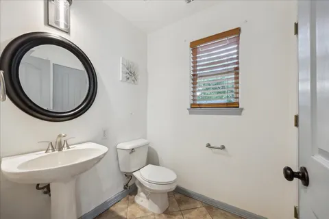 a bathroom with a sink a toilet and a mirror