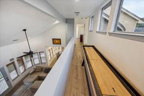 a view of a hallway with wooden floor and stairs