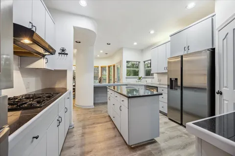 a kitchen with stainless steel appliances granite countertop a stove a refrigerator and a sink