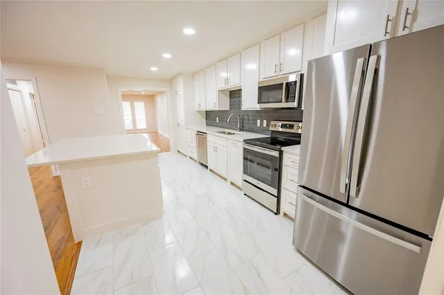 a kitchen with stainless steel appliances a refrigerator sink and microwave