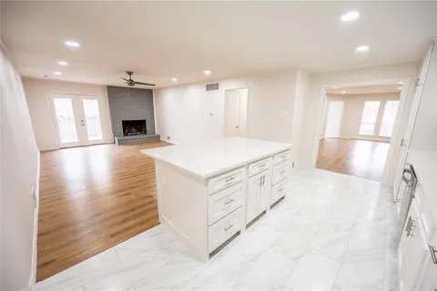a kitchen with stainless steel appliances kitchen island granite countertop a refrigerator and a sink