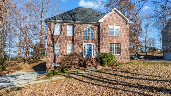 front view of a brick house with a large tree