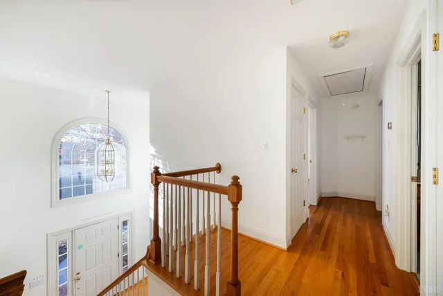 a view of a livingroom with wooden floor and chandelier fan