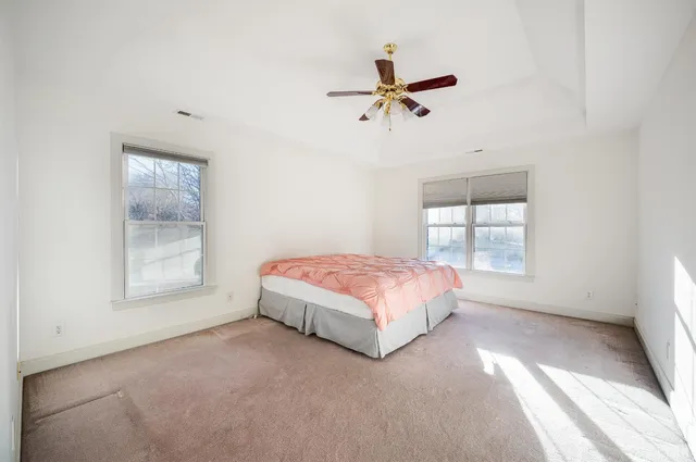 an empty room with a ceiling fan and window