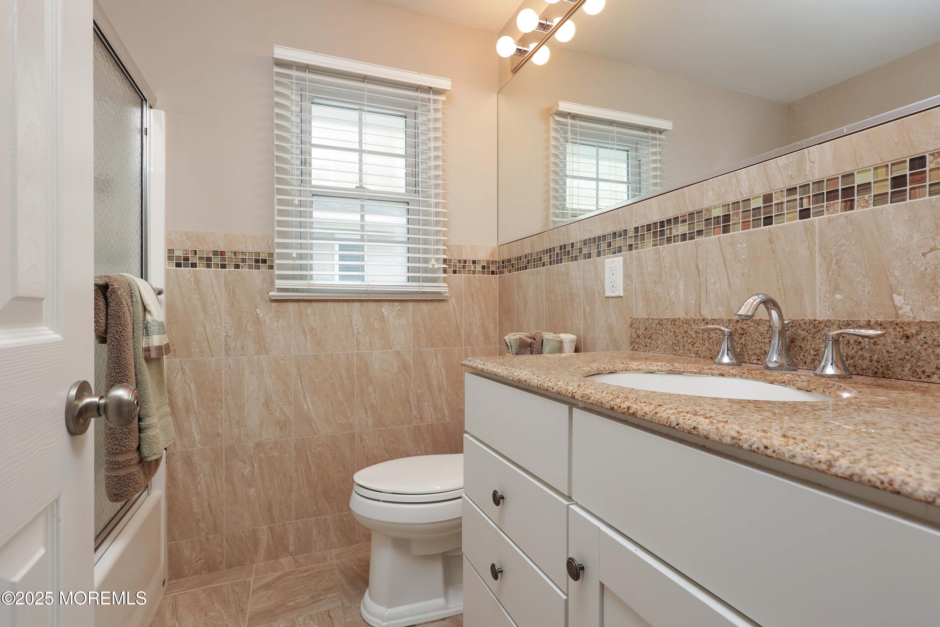 41 Longpoint Drive Brick, NJ 08723 - Photo 13 of 22 a bathroom with a granite countertop sink a toilet a mirror and shower