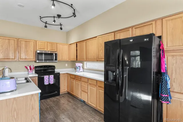 a kitchen with stainless steel appliances granite countertop a refrigerator and a sink
