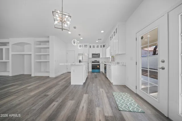 a view of a kitchen with wooden floor and windows