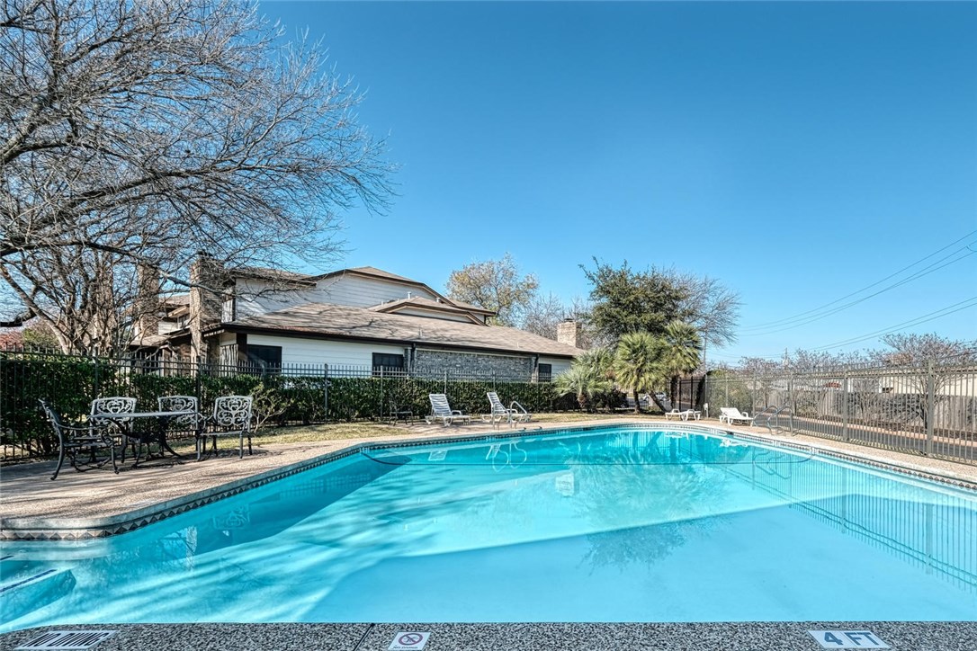 1748 Ohlen Road, Unit 74 Austin, TX 78757 - Photo 15 of 15 a view of a swimming pool with lawn chairs under an umbrella