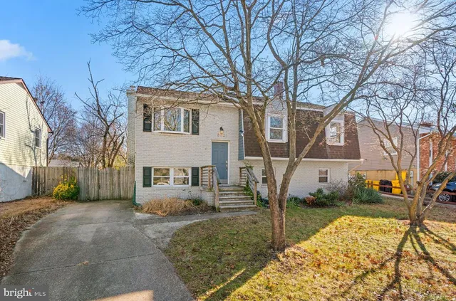 a view of a white house with a large tree