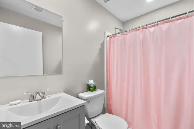 a kitchen with stainless steel appliances granite countertop a refrigerator a stove a kitchen island a dining table and chairs