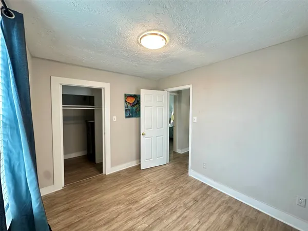 an empty room with closet and wooden floor