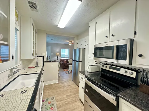 a kitchen with stainless steel appliances a stove a sink and a microwave