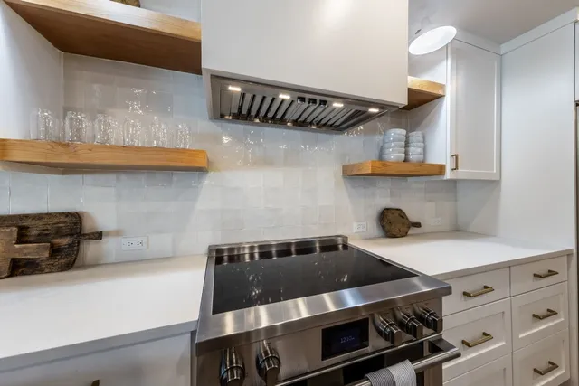 a kitchen with a stove and a white cabinets