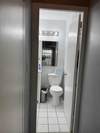 a bathroom with a toilet and a mirror