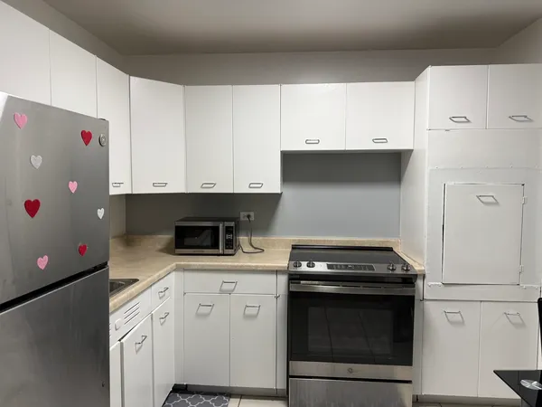 a kitchen with granite countertop white cabinets and white appliances