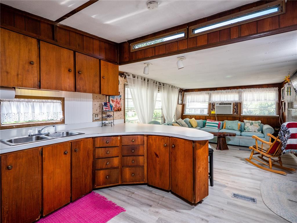 23673 Northeast 134th Lane Road Fort McCoy, FL 32134 - Photo 11 of 34 a kitchen with stainless steel appliances granite countertop a sink dishwasher cabinets and couches with a fireplace