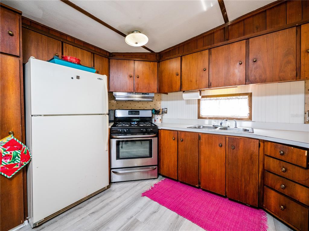 23673 Northeast 134th Lane Road Fort McCoy, FL 32134 - Photo 12 of 34 a kitchen with stainless steel appliances granite countertop a refrigerator and a stove top oven