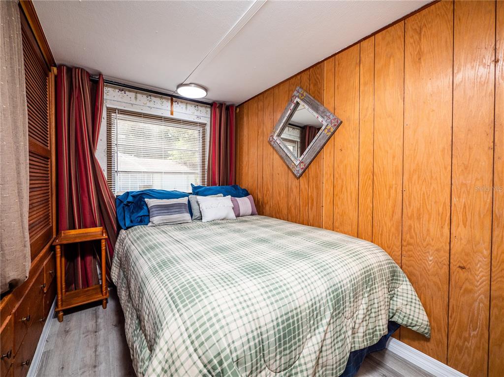 23673 Northeast 134th Lane Road Fort McCoy, FL 32134 - Photo 14 of 34 a bedroom with a bed and wooden floor