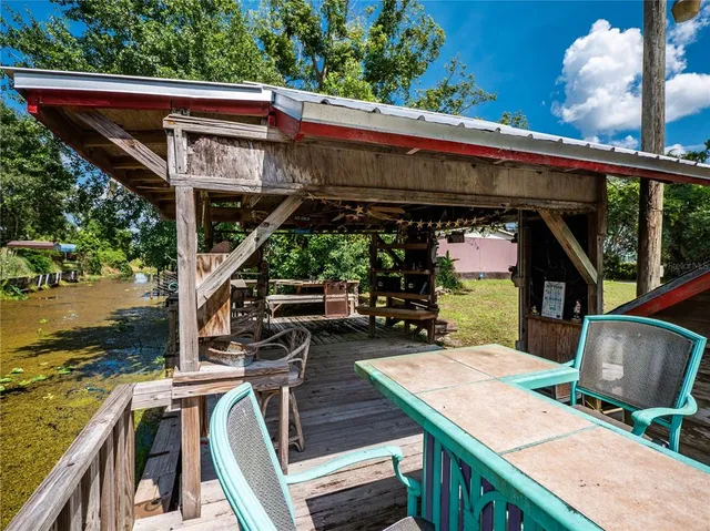 a view of a house with wooden deck and furniture