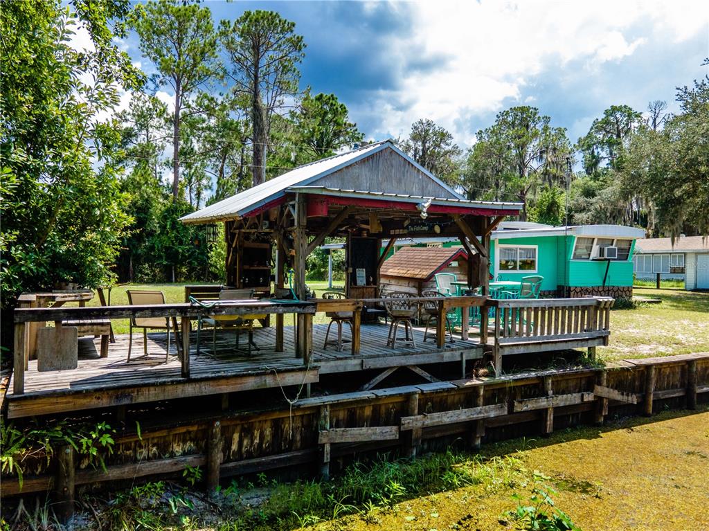 23673 Northeast 134th Lane Road Fort McCoy, FL 32134 - Photo 29 of 34 a view of a house with wooden deck and furniture